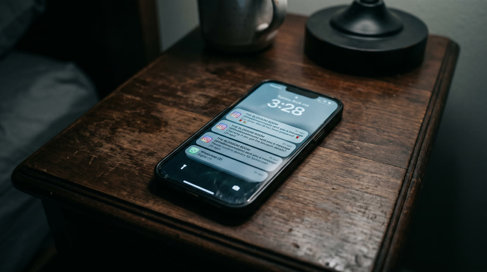 Phone on dark nightstand at 3:28am with unread DMs